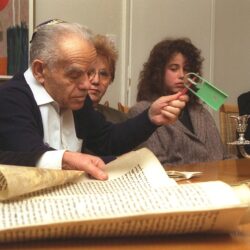 P.M. Yitzhak Shamir waving a noisemaker at the sound of Haman's name during a Megilla reading at his home in Jerusalem on Purim, 28 February 1991. (credit: Ayalon Maggi, CC0)